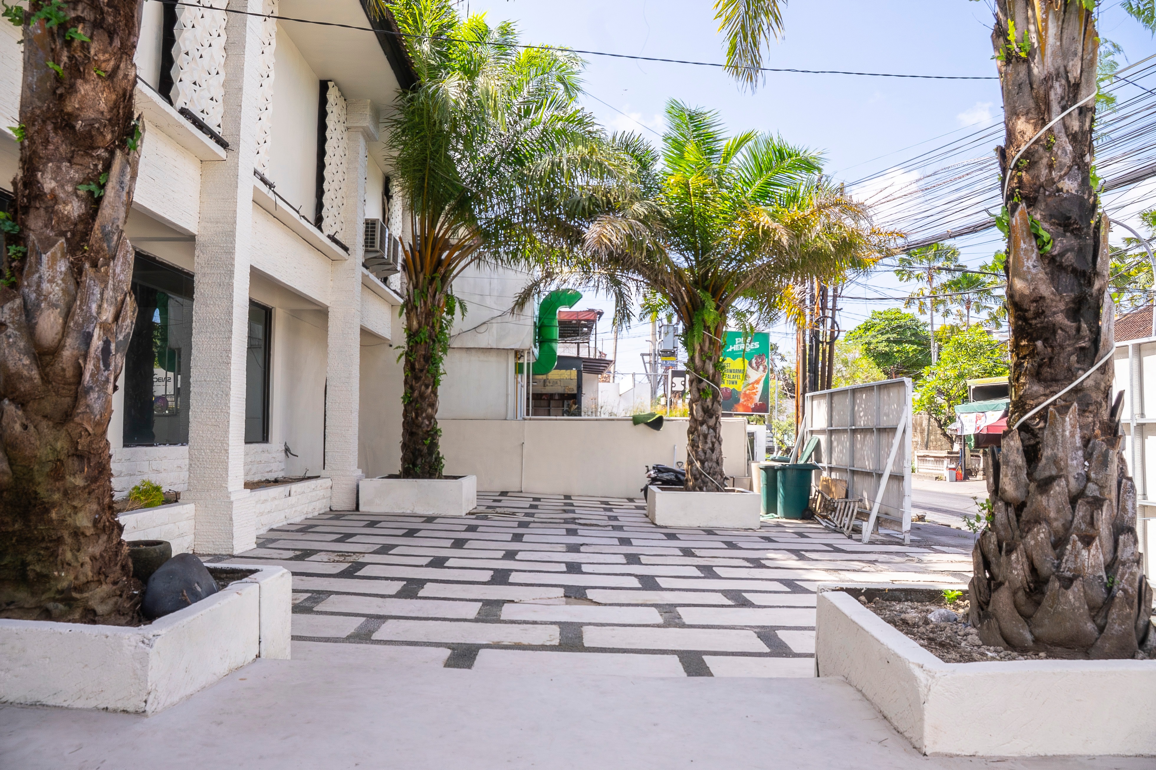 Outdoor courtyard with palm trees and patterned tile flooring